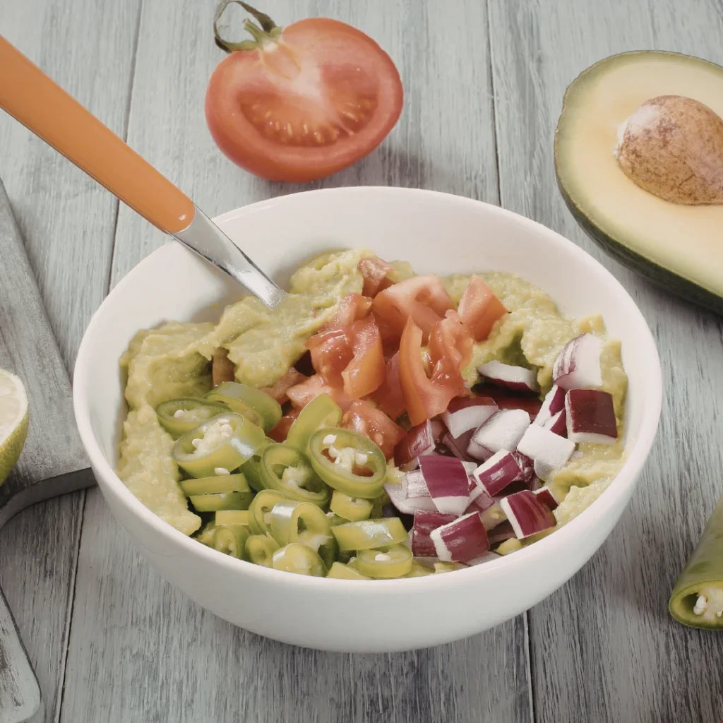 Guacamole sendo misturado com ingredientes frescos