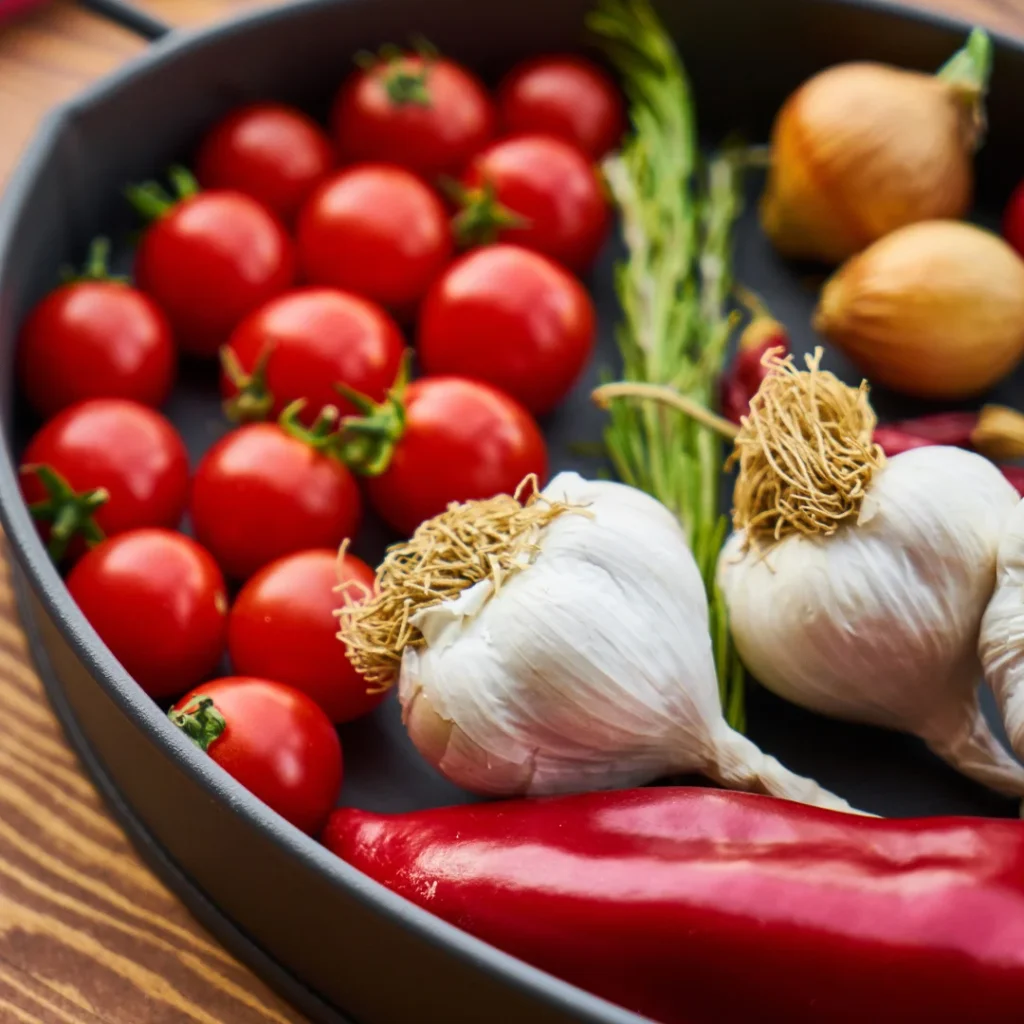 Tomates, pimentas vermelhas, alho e cebola para preparo de salsa roja